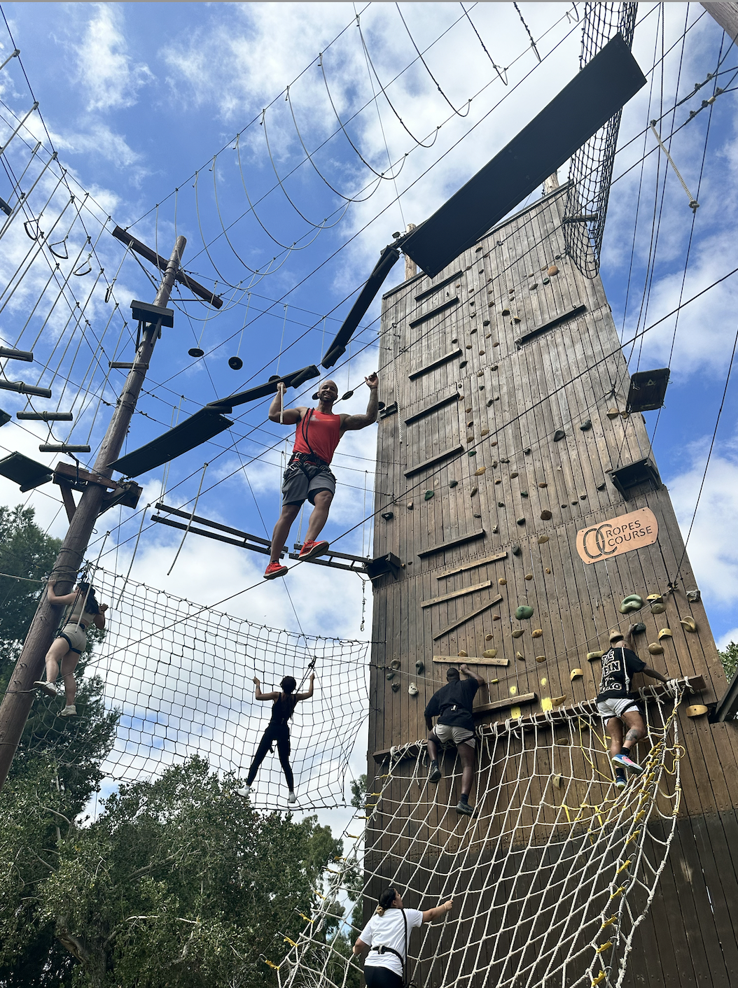 True Vision team members climbing, zip-lining, and tackling challenges at the OC Ropes Course
